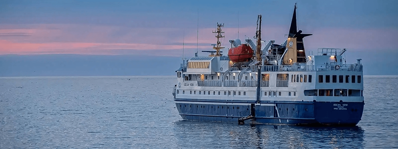 Expedition vessel on Arctic waters at dusk