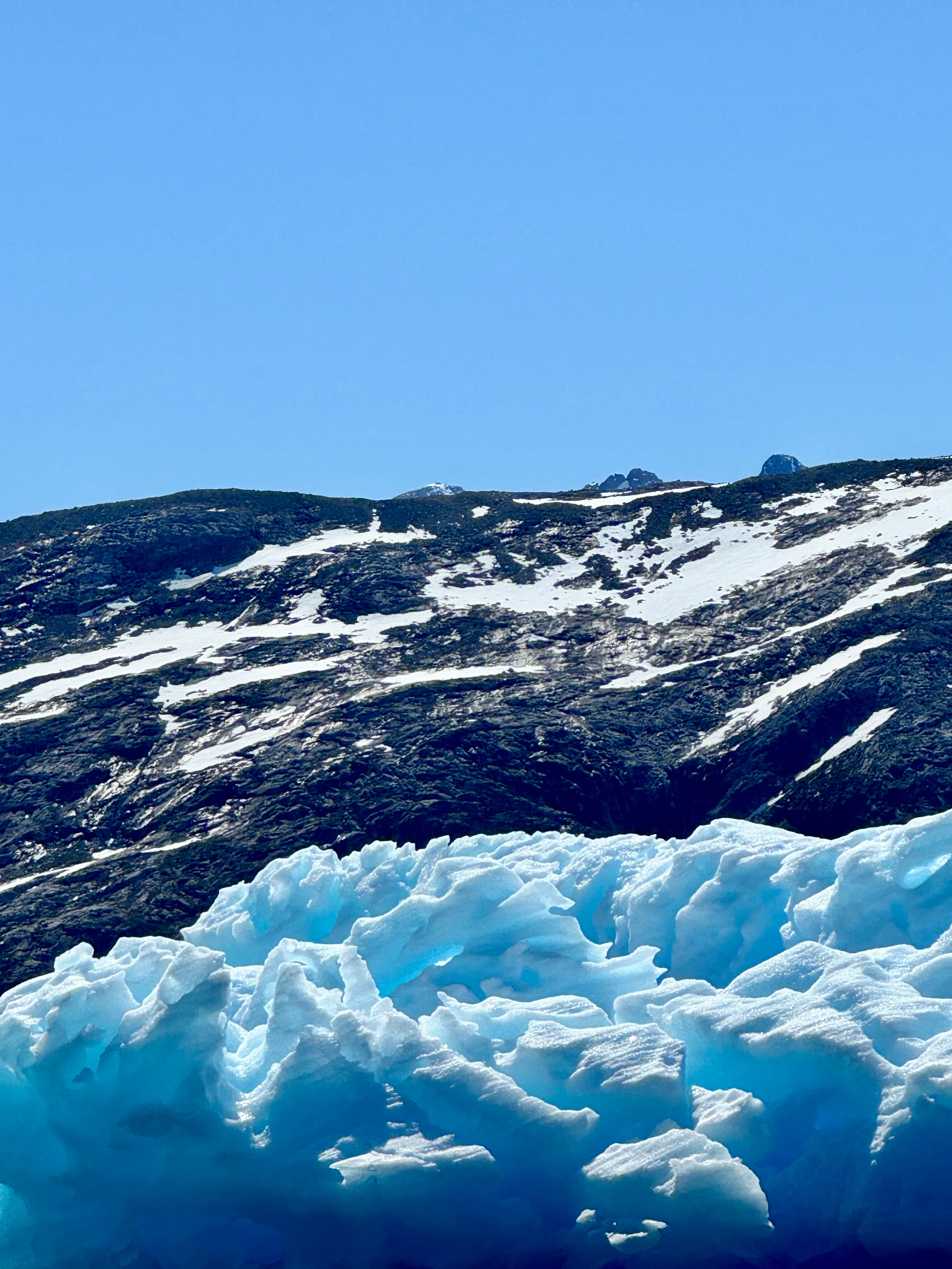 Ice formations and a snowy ridge under a clear blue sky